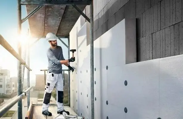 trabajador instalando Sistema de Aislamiento Térmico por el Exterior Instalación de un Sistema de Aislamiento Térmico por el Exterior SATE